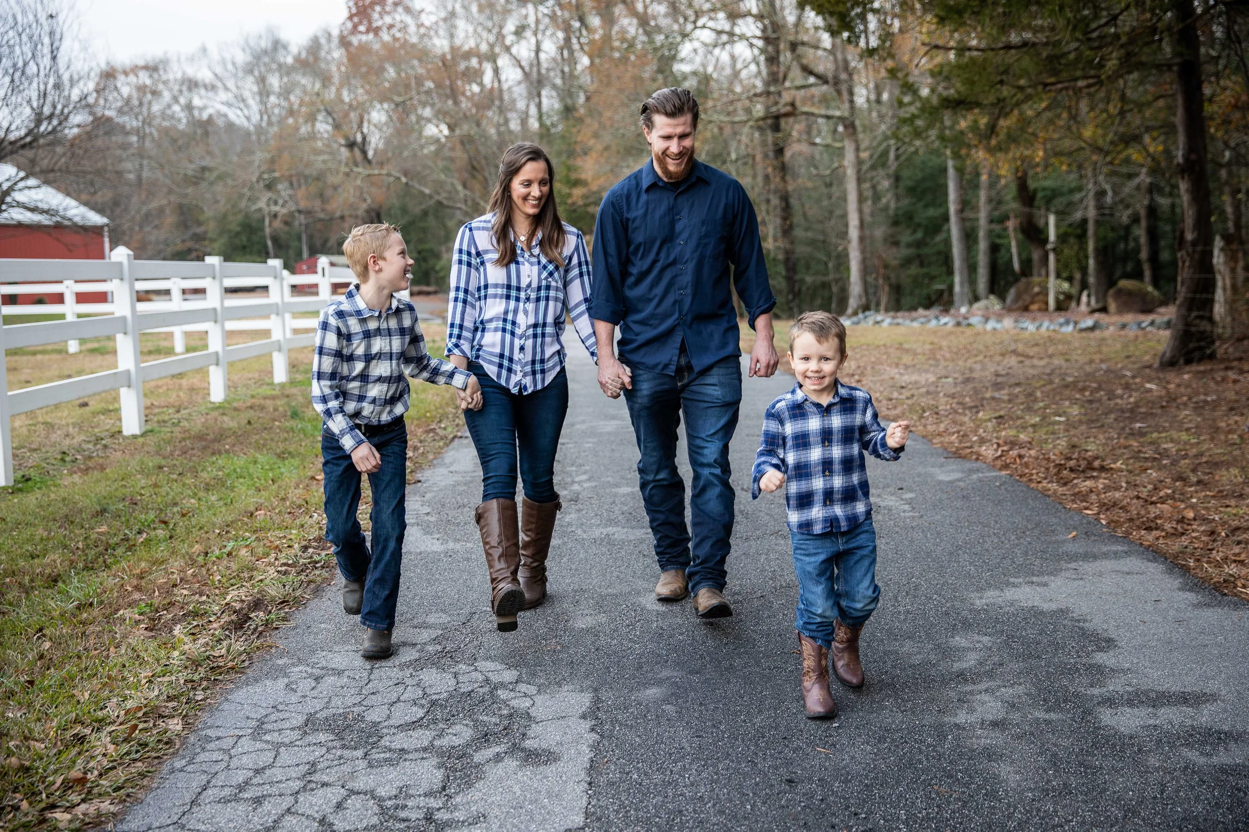 Jessica, Travis and their two boys walking the lane at Sweet Southern Farms