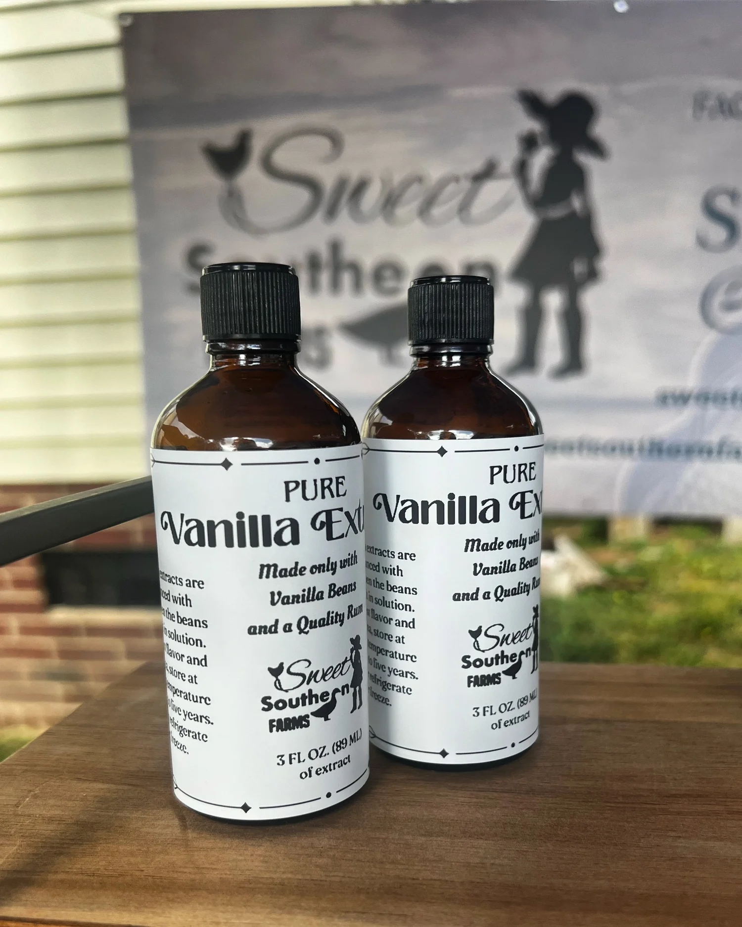 Two bottles of Sweet Southern Farms pure vanilla extract by the farm sign